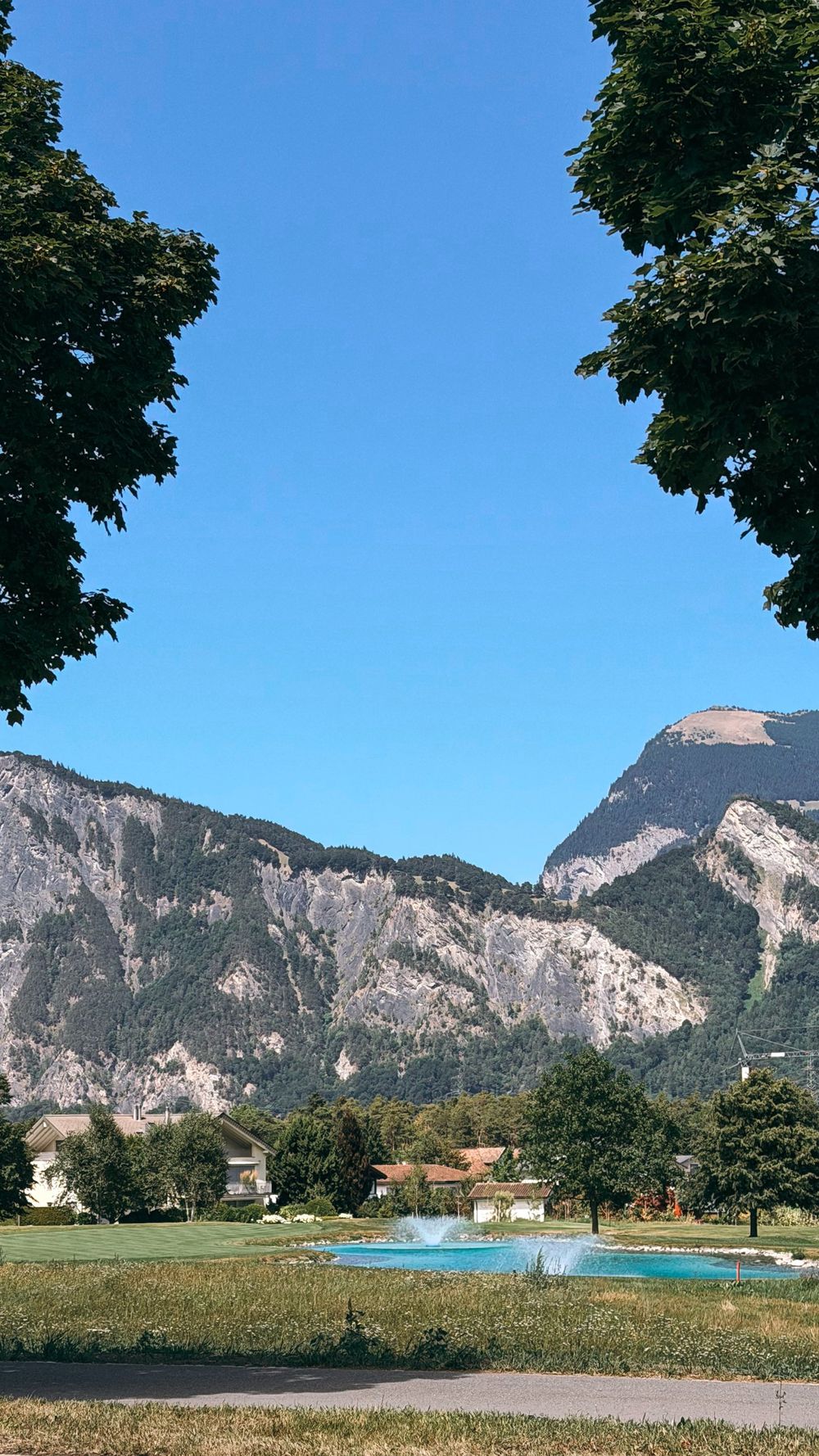 A pond with fountains and mountains in Bad Ragaz