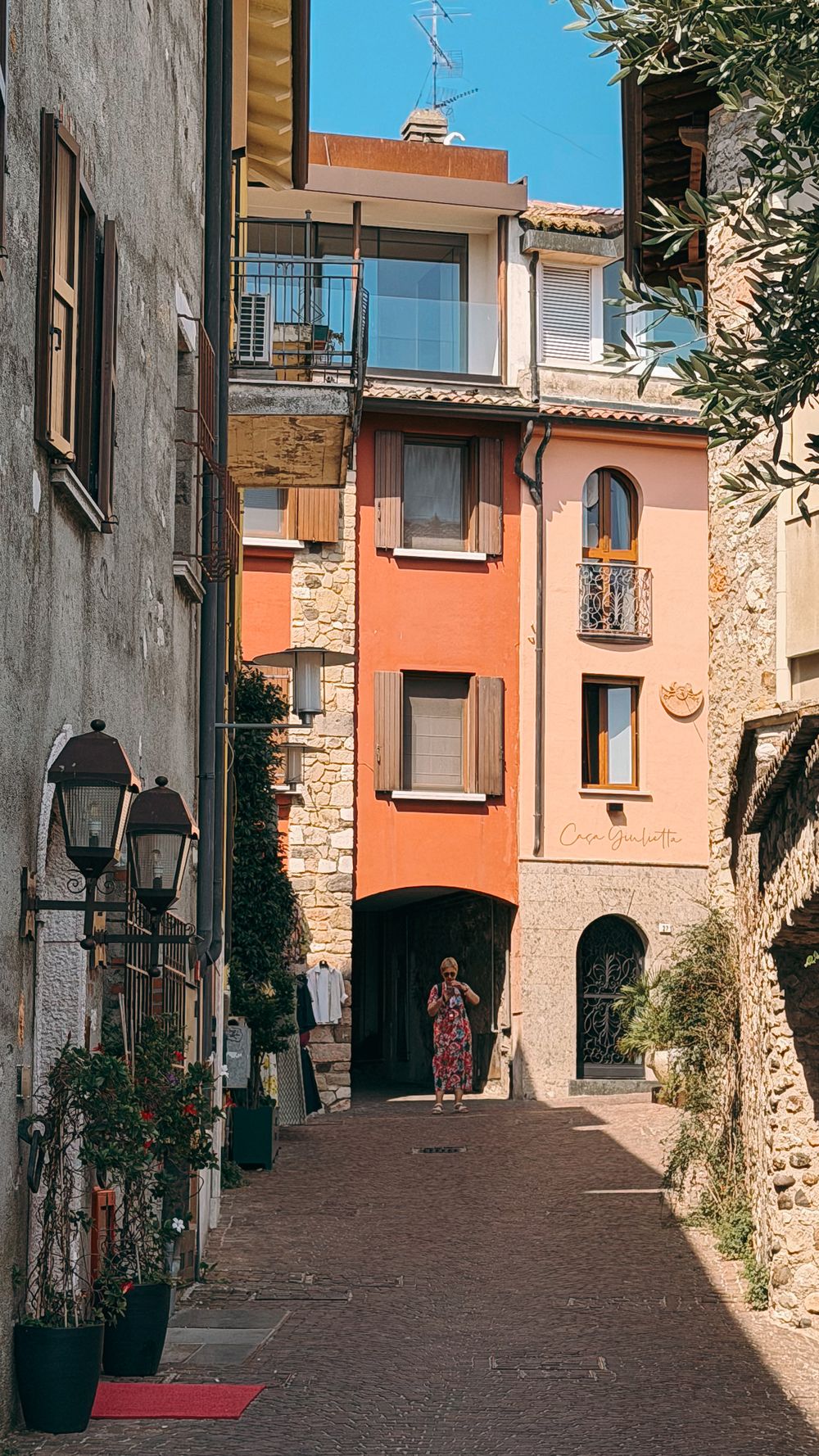 A narrow alley with orange and pink houses in Sirmione