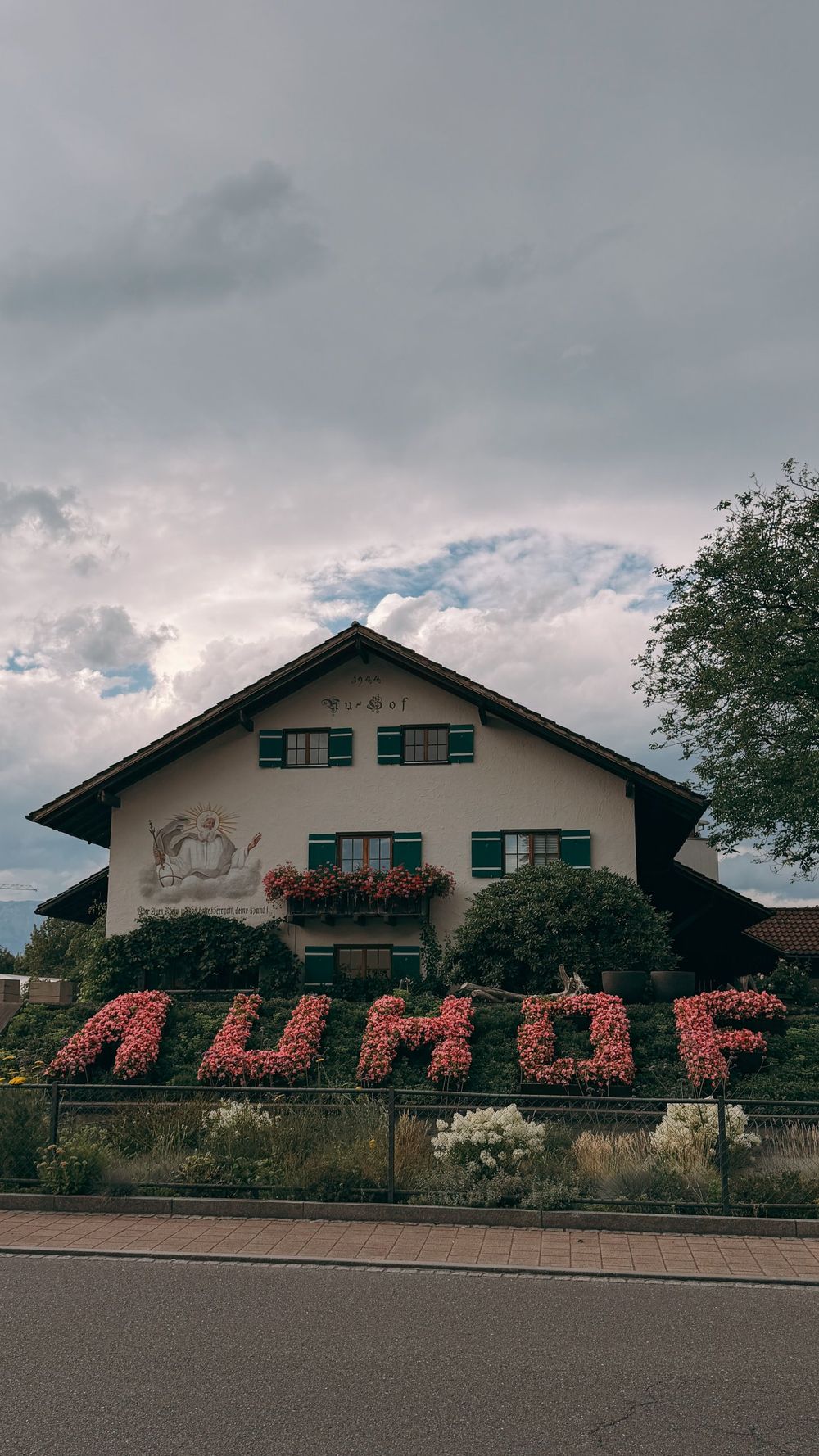 A farmhouse with AUHOF spelled in pink flowers
